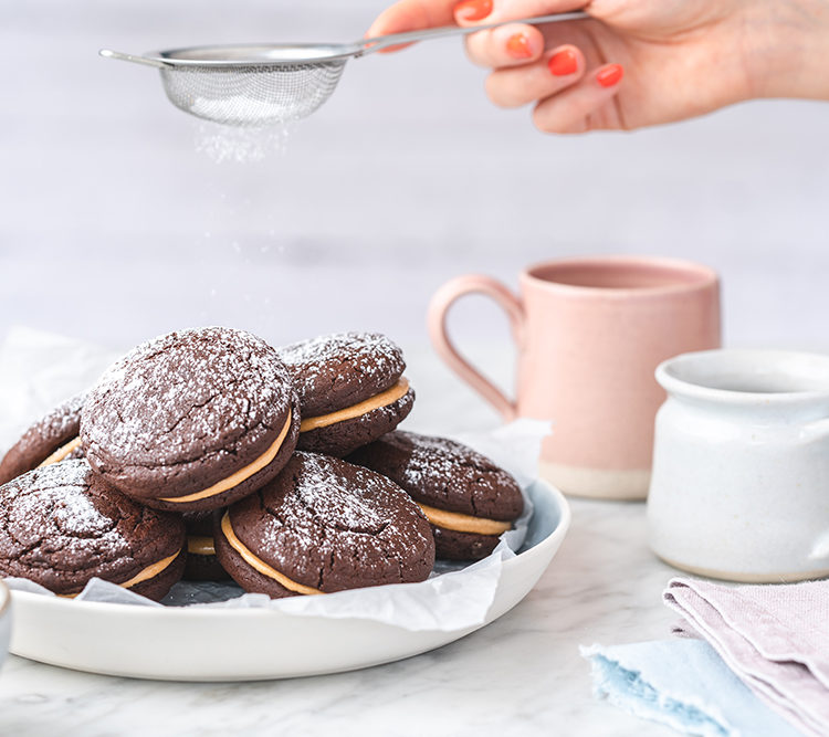 Icing sugar being sprinkled onto cakes as part of a studio photography shoot